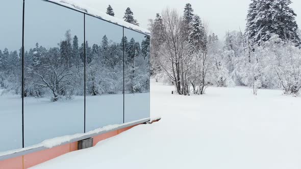 Aerial View of an Innovative Hi-tech House with Mirrored Transparent Walls in Winter Near a