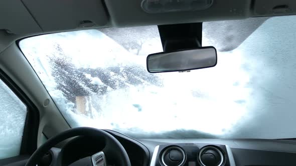 Cleaning Car Windshield of Snow alt
