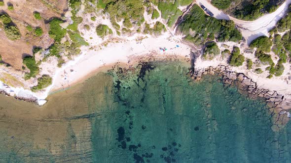 Panoramic aerial drone view of coastline with people sunbathing and relaxing