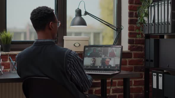 Man Attending Business Meeting with Colleagues on Video Call