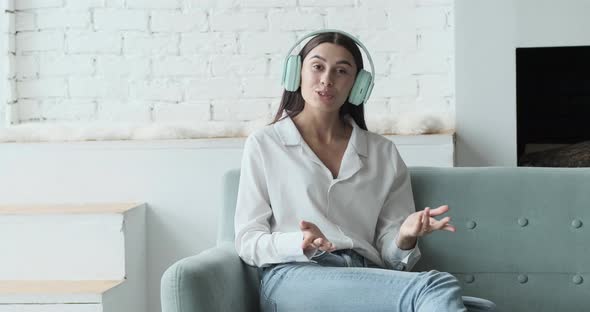Happy Woman in Headphones Looking at Camera Enjoying Video Meeting with Friends and Colleagues