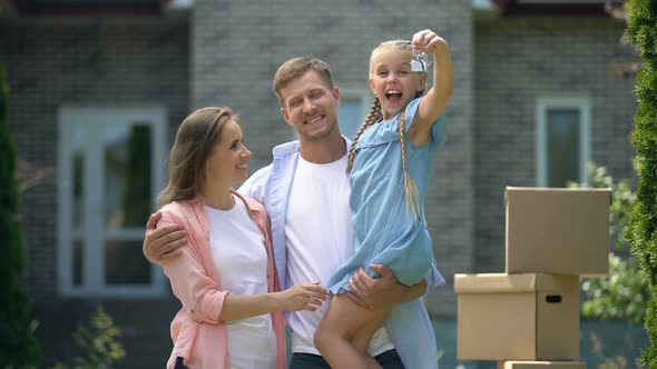 Excited Girl Showing Keys From House