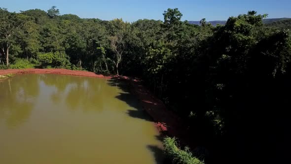 Drone flying backwards over a small pond on a fish farm in the Tocantins region of Brazil