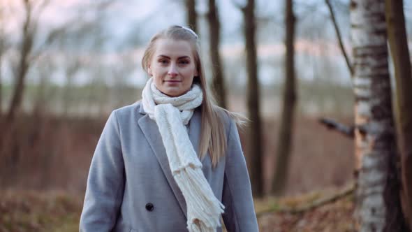Portrait of Positive Woman Walking in Park in Autumn