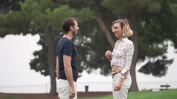 A Man and a Woman Slow Dancing in a Park in the Rain in Slow Motion