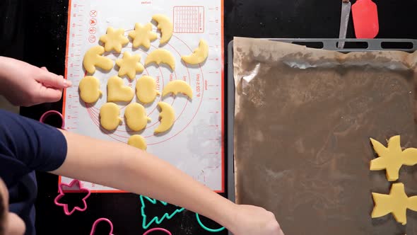 Unrecognizable Woman and Boy Spread Out Dough of Different Shapes on a Baking Sheet Slow Motion