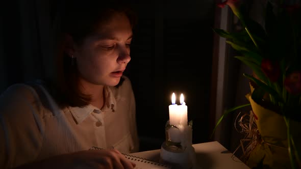 a girl looking the burning candles, blowing out the candles in the room