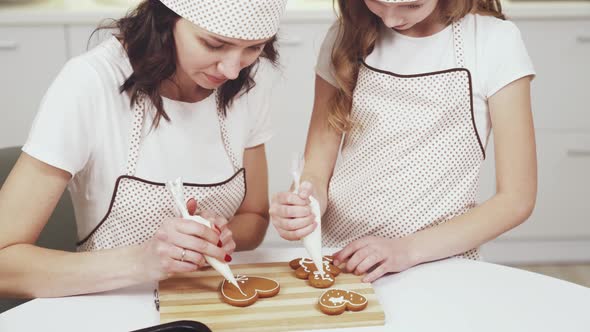 Charming Woman and Little Girl Decorating Ginger Cookies