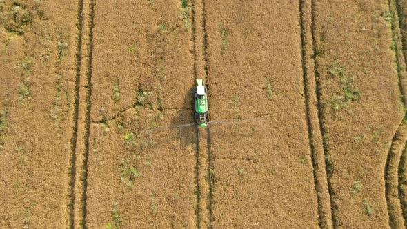 Tractor Sprays Over The Fertilizer Field