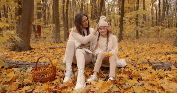 Young Mom and Daughter on a Picnic in Autumn