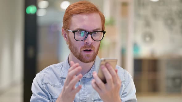 Portrait of Upset Casual Redhead Man Having Loss on Smartphone 