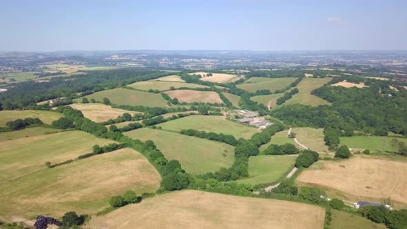 Aerial drone footage over rolling green farmland pastures in Exeter outskirts