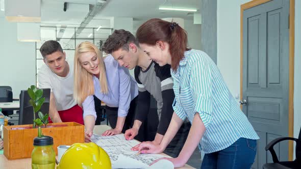 Young Architects Working Together on a Blueprint at the Office