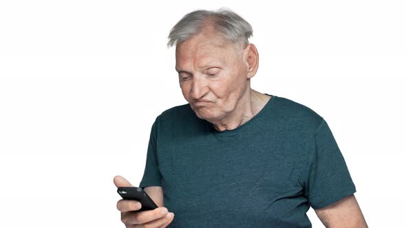 Portrait of Content Retired Man 80s Having Gray Hair and Blue Eyes Browsing Internet on Smartphone