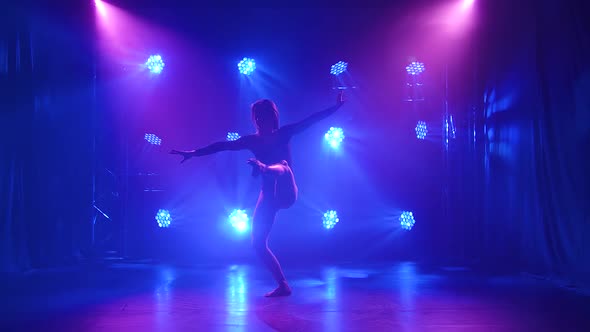 Woman Dancing Modern Dance at Smoky Stage with Spotlights. Vogue or Contemporary Dance. Young Dancer