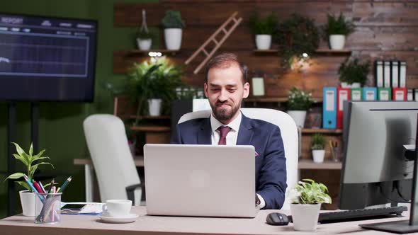 Portrait of Young Handsome Businessman Working on Laptop