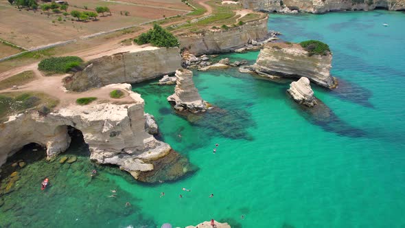 4K aerial of the rock formations of Sant'Andrea near Torre Dell'Orso, Apulia, Italy in the summer.