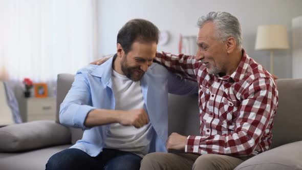 Aging Father and Middle Aged Son Punching Fists Friendly Family Relations, Trust