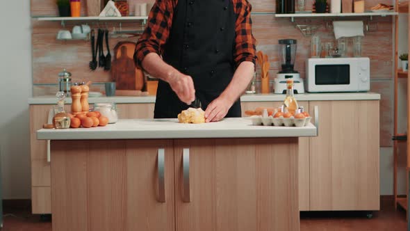 Old Man with Kitchen Apron Cooking Bread