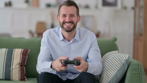 Excited Young Man Playing and Winning Video Game