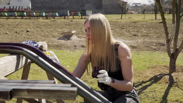 A Young Girl Paints Pipes in the Backyard of Her House