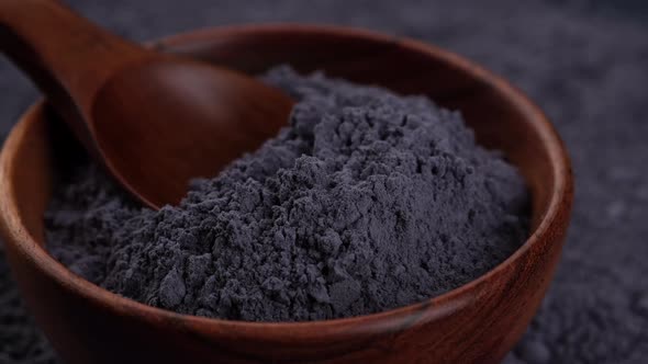 Blue butterfly pea powder in wooden bowl close up.  superfoods