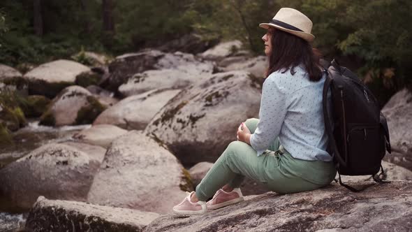 Portrait of a Traveler Resting Sitting on Stones By the River