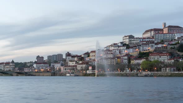 Timelapse of Coimbra at sunset with color light fountain in mondego river, in Portugal