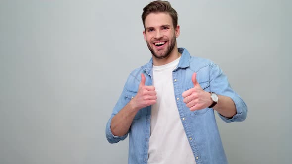 Smiling young caucasian man showing thumbs up