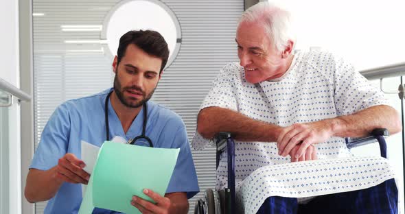 Doctor discussing reports with senior patient on wheelchair