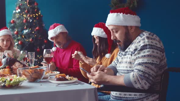 Family with Man in Wheelchair Uses Phones During Christmas Holiday