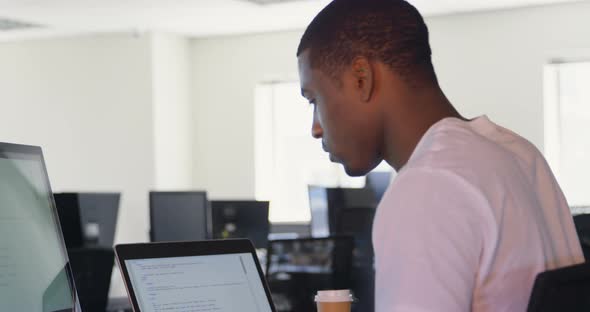 Side view of young black male executive working at desk in office 4k