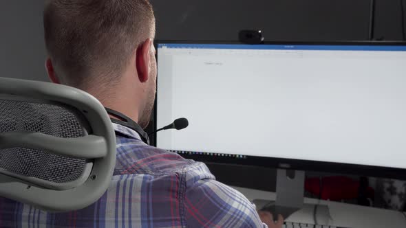 Handsome Call Center Operator Smiling To the Camera After Typing on His Computer