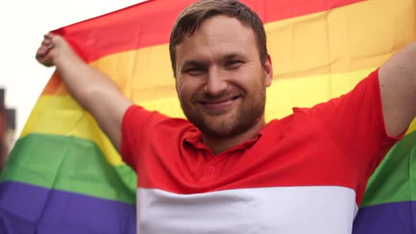 Young Man with LGBT Flag Standing Outdoor. A Close Portrait of a Young Guy Fighting for Homosexual