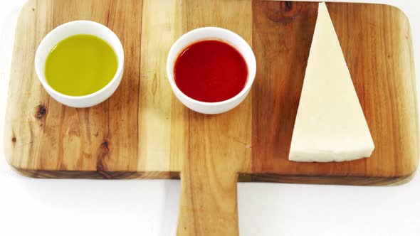 Cheese slice and sauce on cutting board with boiled pasta