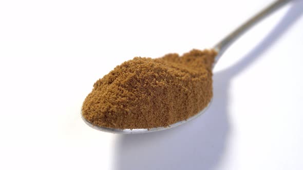 A full teaspoon of dry instant chicory root powder on a white background. Caffeine free