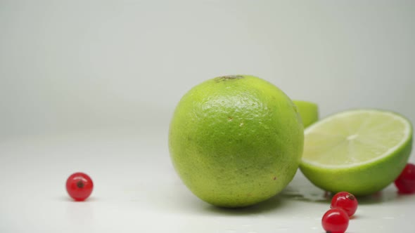 Fresh Green Limes and Red Currants With White Background - Close Up Shot