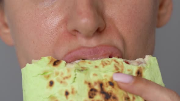 Woman Eating Spinach Shawarma with Chicken and Vegetables Close-up
