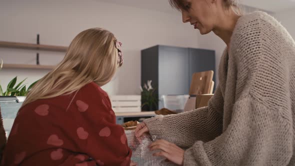 Caucasian mother and daughter packing kitchen stuff. Shot with RED helium camera in 8K