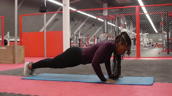 Sports Training  Africanamerican Woman Doing Push Ups in the Gym
