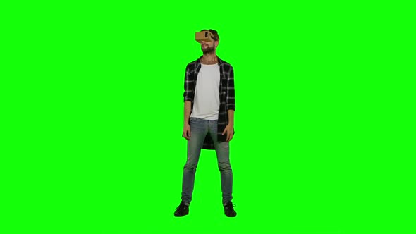 Young Man Playing Game Using VR-helmet for Smart Phones, Green Screen