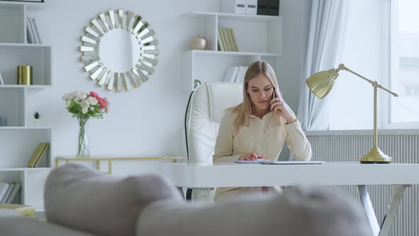 Young woman talking on the phone at home office