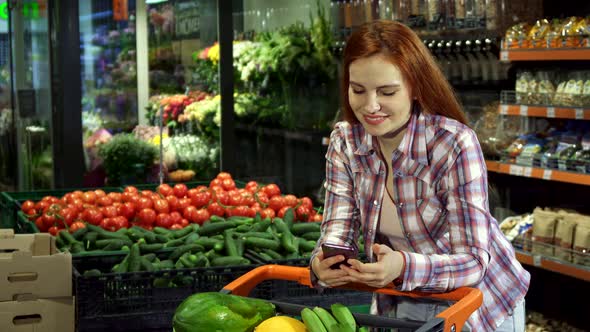 Woman Browsing Her Shopping List on Her Smartphone