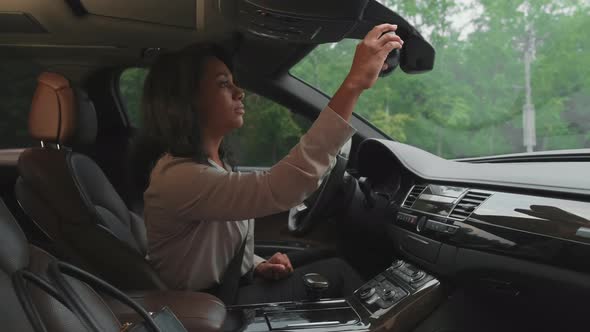 Business Lady Adjusting Rear-View Mirror
