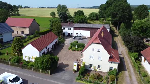 From the farm courtyard to the church spire.Breathtaking aerial view flight fly backwards drone foo