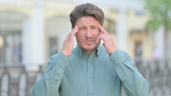 Tense Middle Aged Man having Headache