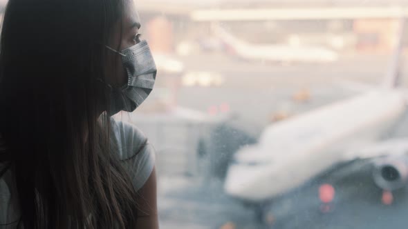 Side View, Portrait of Woman in Protective Mask Looks in Airport Window COVID-19