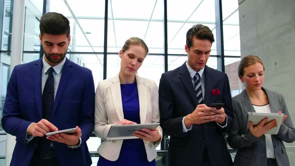 Business executives using mobile phone and digital tablet