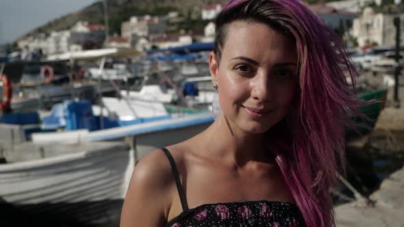 Bright Young Girl with Colored Hair Stands on the Embankment