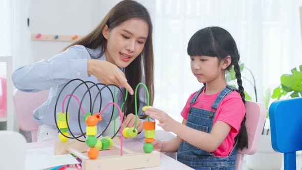 Asian beautiful young woman teacher teaching mixed race kids at school.